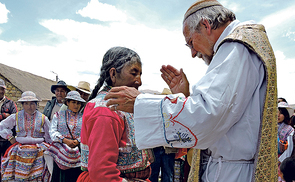 Eine Frau in traditioneller Tracht wird gesegnet.